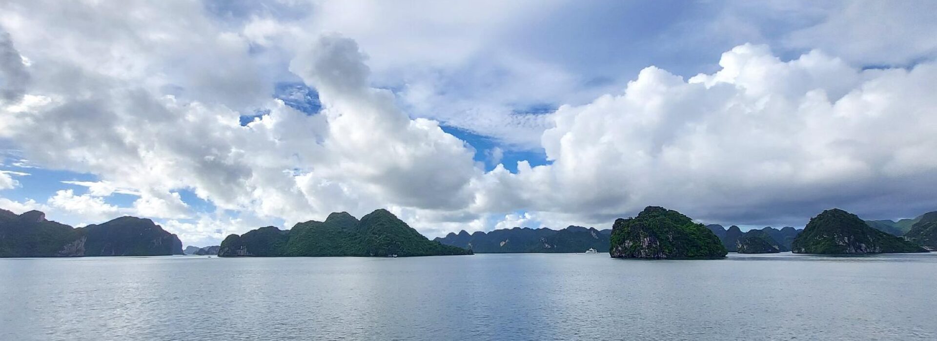 Toàn cảnh vịnh biển với các đảo đá và mây trắng